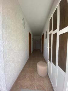 an empty hallway with a white wall and a stool at Apartman "Niko" in Povile