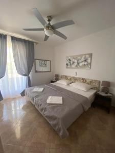 a bedroom with a large bed with a ceiling fan at Apartman "Niko" in Povile