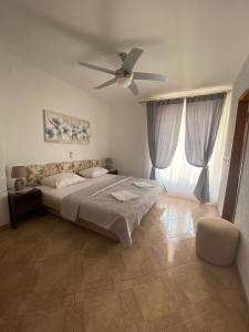 a bedroom with a bed and a ceiling fan at Apartman "Niko" in Povile
