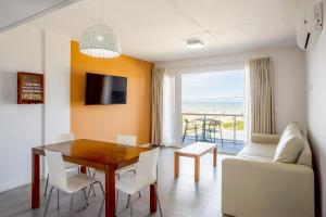 a dining room with a table and a couch at Departamento Apart Espacio Marina in Villa Gesell