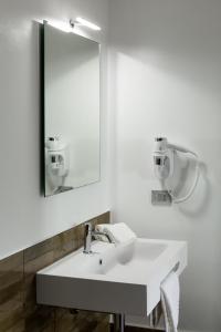 ein weißes Badezimmer mit einem Waschbecken und einem Spiegel in der Unterkunft CinqueStanze Affittacamere in Messina