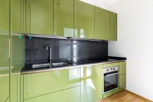 uma cozinha com armários verdes e um lavatório em Casa Bassani con terrazzo by Wonderful Italy em Bolonha