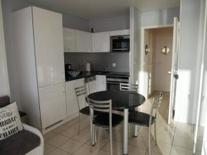 uma cozinha com mesa e cadeiras num quarto em Studio Quiberon, 1 pièce, 3 personnes - FR-1-478-41 em Quiberon