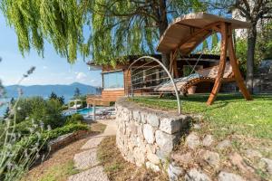 a house with a slide and a stone wall at Villa Vela in Torri del Benaco