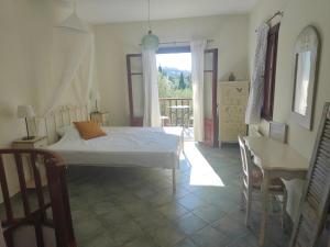 Schlafzimmer mit einem Bett, einem Tisch und einem Fenster in der Unterkunft Alkyon Villas in Syvota