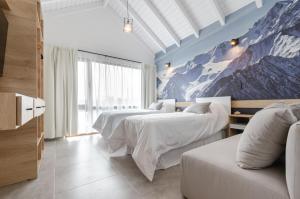 a bedroom with two beds and a mountain mural at Villa Huapi in Dina Huapi