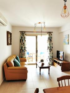 a living room with a couch and a table at Escape and relax cozy apartment in Pafos! in Mandria