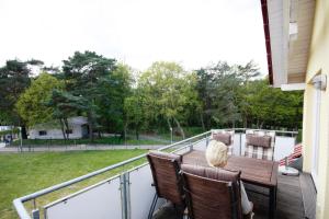 a balcony with a wooden table and chairs on it at Ferienwohnungen Seevogel in Ostseebad Koserow