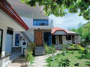 a house with a gate and a balcony at CHIEF'S VILLA Rentals Malapascua Island in Malapascua Island