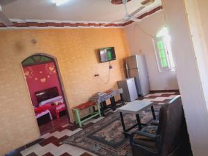 a living room with a refrigerator and a table at Algaafary GeustHouse in Aswan
