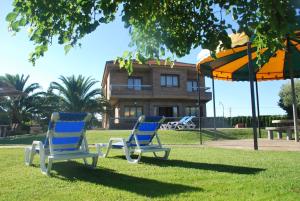 twee blauwe stoelen in het gras voor een gebouw bij Casa La Nava in Olite