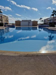 a large swimming pool with blue water at Escape and relax cozy apartment in Pafos! in Mandria