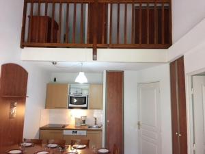 - une cuisine avec une table et un four micro-ondes dans l'établissement Duplex 7 pers. avec parking, piscine, fitness, proche pistes - La Mongie - FR-1-404-205, à La Mongie