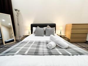 a bedroom with a bed with two towels on it at Queen Street City Centre Apartment in Glasgow