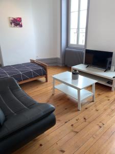 een woonkamer met een bank en een salontafel bij Appartement de la République in La Tour-du-Pin