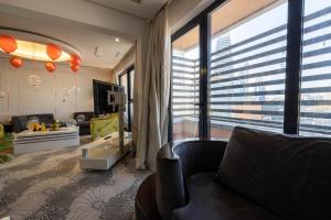 a living room with a couch and a large window at Mira Business Hotel in Riyadh