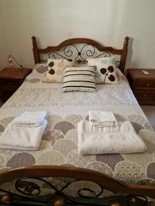 a bed with two towels and pillows on it at Escape and relax cozy apartment in Pafos! in Mandria