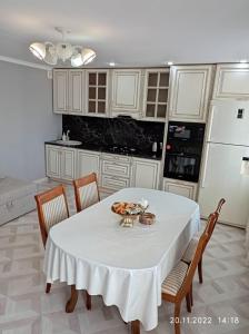 eine Küche mit einem Tisch und einem weißen Tischtuch in der Unterkunft 2-х комнатная квартира посуточно in Kökschetau