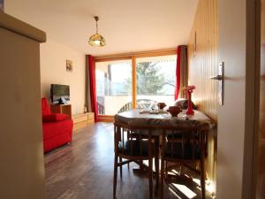 a living room with a table and a red couch at Appartement Puy-Saint-Vincent, 1 pièce, 2 personnes - FR-1-330G-98 in Puy-Saint-Vincent