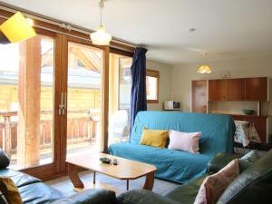 a living room with a blue couch and a table at Bel appartement lumineux 54m², 3 pièces, 6 pers., coeur de Montgenèvre, animaux acceptés, balcon. - FR-1-330D-12 in Montgenèvre