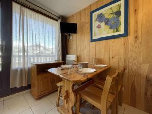 a dining room with a wooden table and chairs at Appartement Montgenèvre, 1 pièce, 4 personnes - FR-1-330D-44 in Montgenèvre