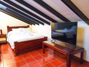 a bedroom with a bed and a flat screen tv at Casona 1865 in Ráquira