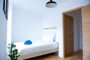 - une petite chambre avec un lit blanc et une porte en bois dans l'établissement La Pomme du Président I, à Sélestat
