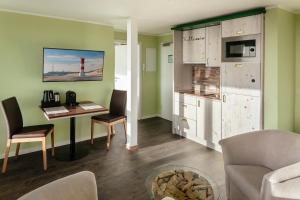ein Wohnzimmer mit einem Tisch und einer Küche in der Unterkunft Insulaner Ferienwohnungen in Helgoland