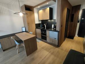 a kitchen with a desk and a table in a room at Magnifique 3 étoiles en hyper centre avec place privée in Aix-les-Bains