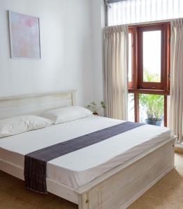 uma cama num quarto com uma janela em Greenscape Colombo em Colombo