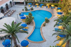 an overhead view of a swimming pool with umbrellas and palm trees at Hotel La Santa Maria in Cala Millor