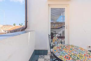 a balcony with a table and chairs and a window at Hotiday Siracusa A'Storia in Syracuse