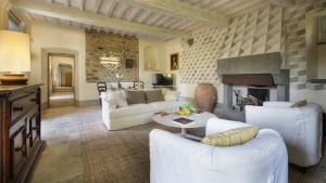 sala de estar con muebles blancos y chimenea en VILLA METELLIANO 10, Emma Villas, en Cortona