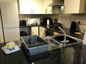 a kitchen with a sink with a tray on it at Sleeps up to 7, Parking, Office, Preston Nr M6 M65 in Preston