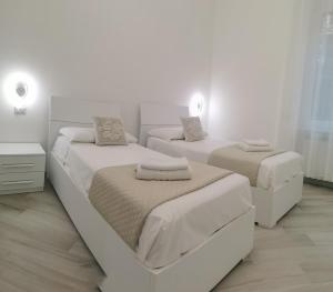 2 letti in una camera da letto con pareti bianche di Residenze Niguarda E a Milano
