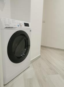 una lavadora blanca sentada en una habitación blanca en Residenze Niguarda E en Milán