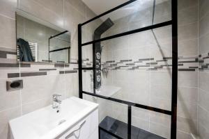 La salle de bains est pourvue d'une douche et d'un lavabo. dans l'établissement Gite du chateau, à Montrond-les-Bains