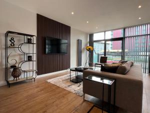 uma sala de estar com um sofá e uma mesa em Stunning Apartment at Glasgow Hydro & SECC - Glasg em Glasgow