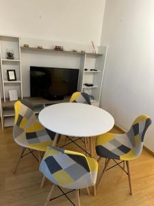 une salle à manger avec une table blanche et quatre chaises dans l'établissement Cosy appartement with free parking a Paris, à Villejuif