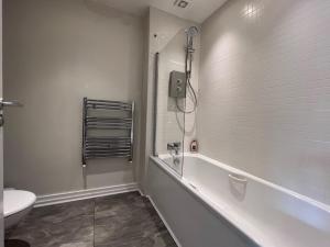 a bathroom with a tub and a toilet and a sink at Stunning Apartment at Glasgow Hydro & SECC - Glasg in Glasgow