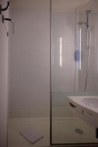 a shower with a glass door next to a sink at ibis Aix en Provence in Aix-en-Provence