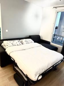 - un lit dans une chambre avec fenêtre dans l'établissement Cosy appartement with free parking a Paris, à Villejuif