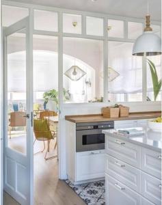 a kitchen with white cabinets and a table at Casa de los Sueños para familias en Madrid in Madrid