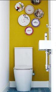 a bathroom with a toilet and plates on the wall at Casa de los Sueños para familias en Madrid in Madrid