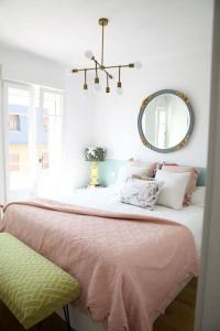 1 dormitorio con 1 cama con manta rosa y espejo en Casa de los Sueños para familias en Madrid, en Madrid