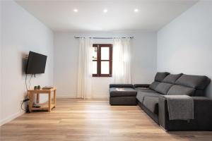 uma sala de estar com um sofá preto e uma televisão em Apartment Sunset Albercutx Pollentia 1 em Port de Pollença