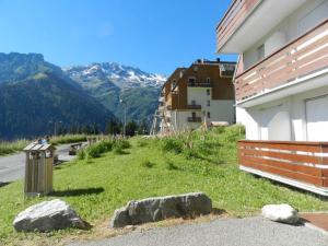 a building with a field of grass next to a mountain at Studio cabine cosy avec balcon, 400m des pistes, casier à skis, proche commerces et remontées mécaniques. - FR-1-557A-15 in La Ferrière