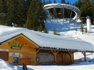 a ski lodge with a ski lift in the background at Appartement Le Pleynet, 1 pièce, 4 personnes - FR-1-557A-15 in La Ferrière