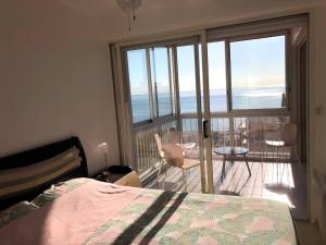 1 dormitorio con cama y vistas a un balcón en Appartement Le Barcarès, 4 pièces, 6 personnes - FR-1-81-525 en Le Barcarès