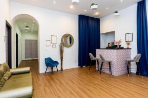 uma sala de estar com uma mesa e cadeiras azuis em Adagio Downtown Rooms em Budapeste